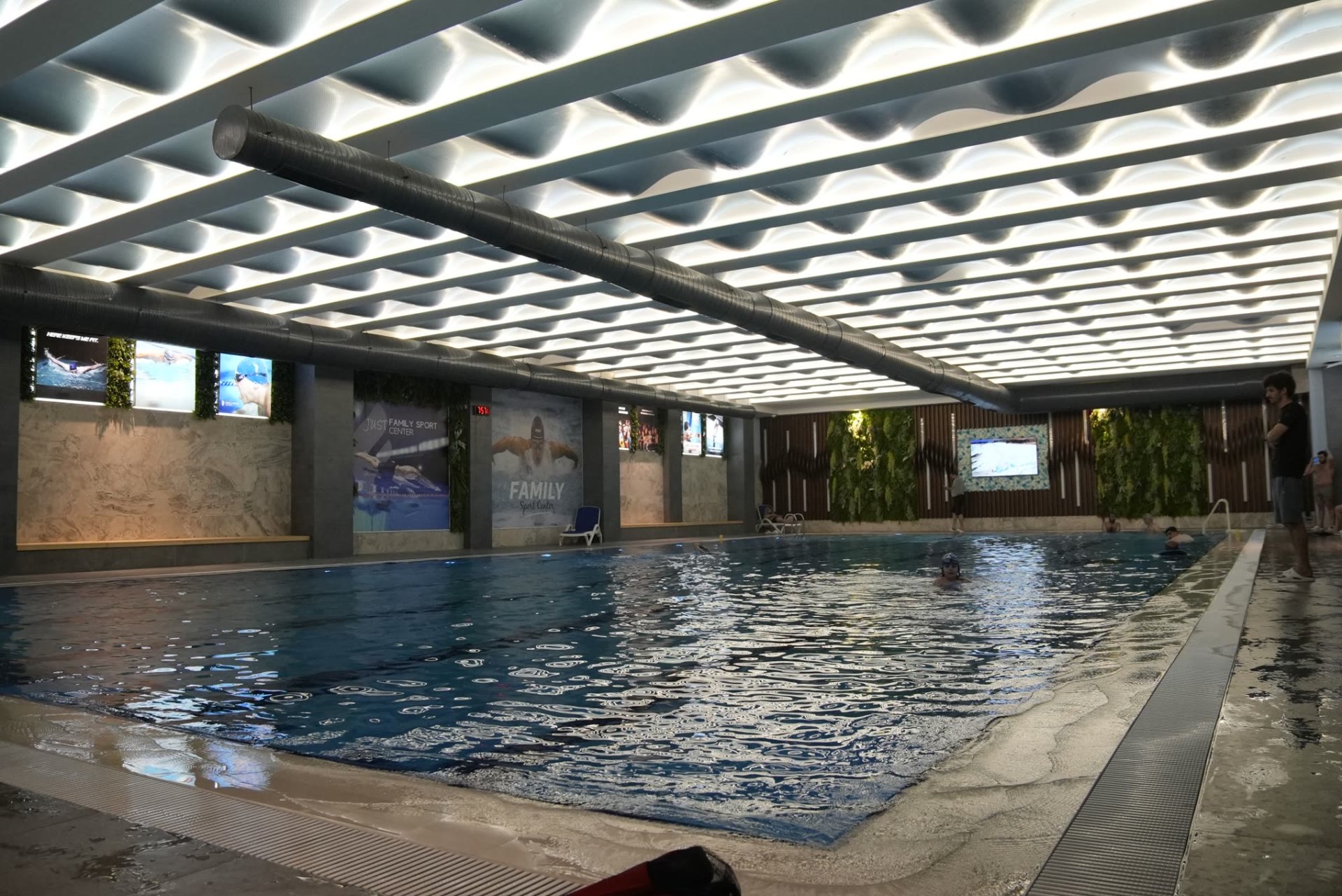 The indoor lap pool under a lit wave ceiling